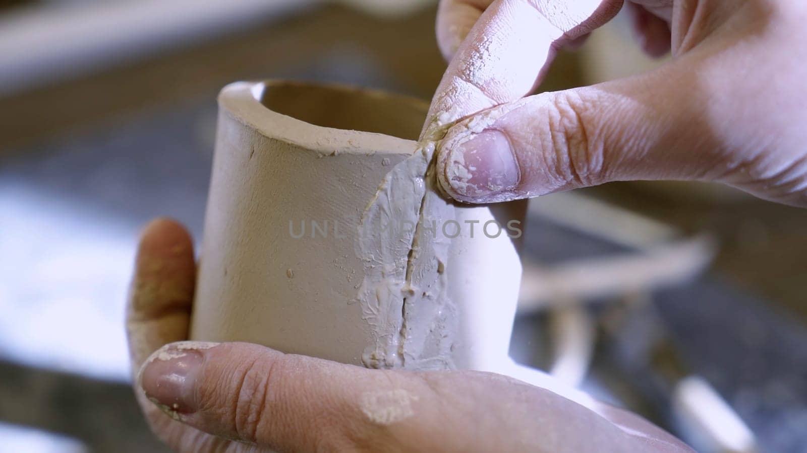 Hands skillfully repairing a delicate ceramic piece, showcasing the intricate artistry involved in pottery making. Stock Clip