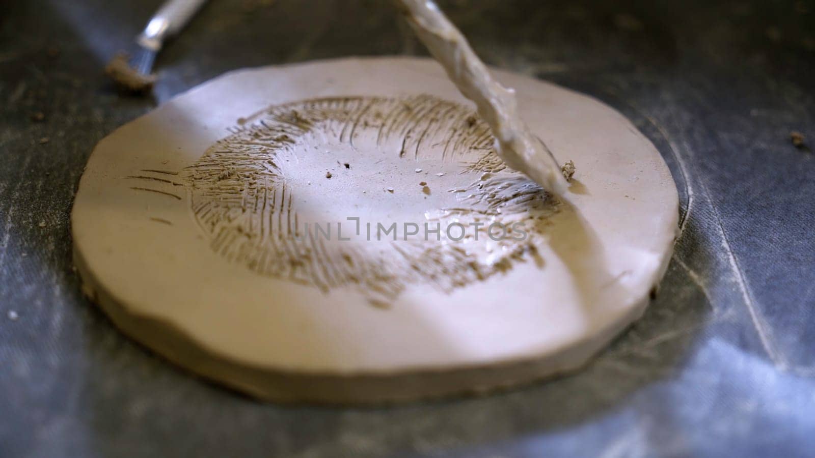Creating captivating and intricate artwork using various tools on a beautifully textured clay surface. Stock Clip