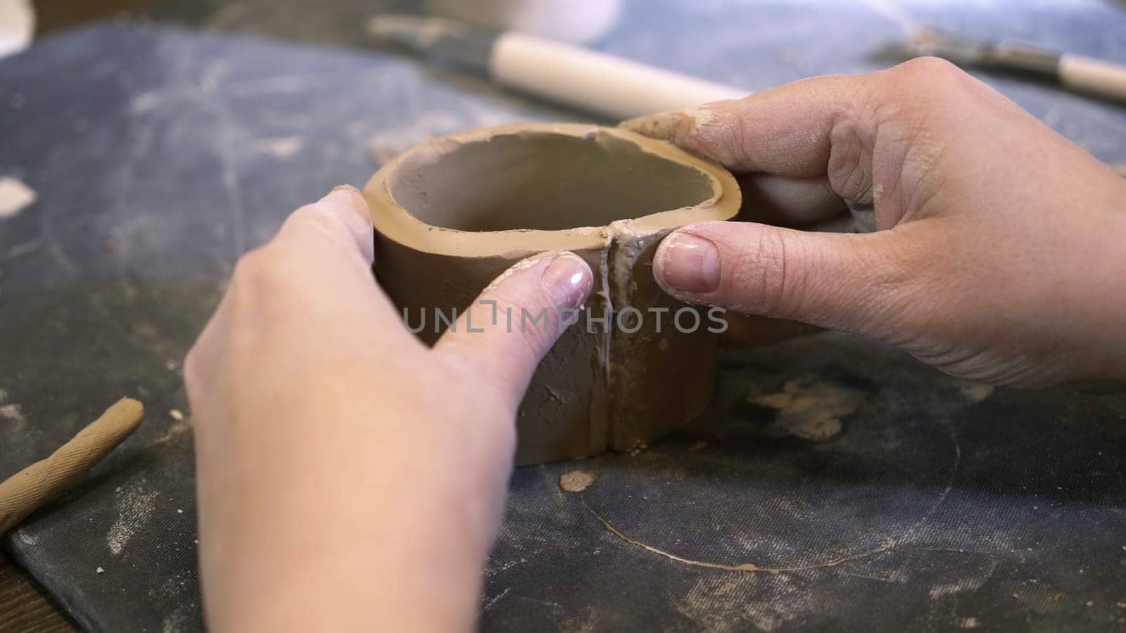 Close up of hands shaping clay into a round pot in a pottery studio, highlighting creativity and artistry. Stock Clip