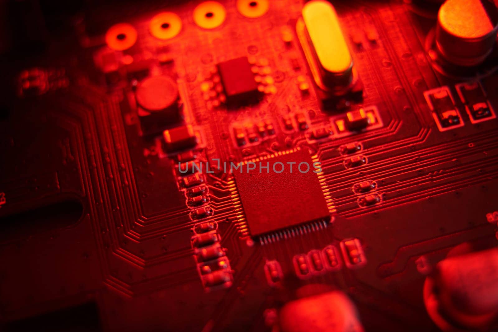 A visually striking macro shot featuring a detailed circuit board illuminated with vibrant red hues and tones
