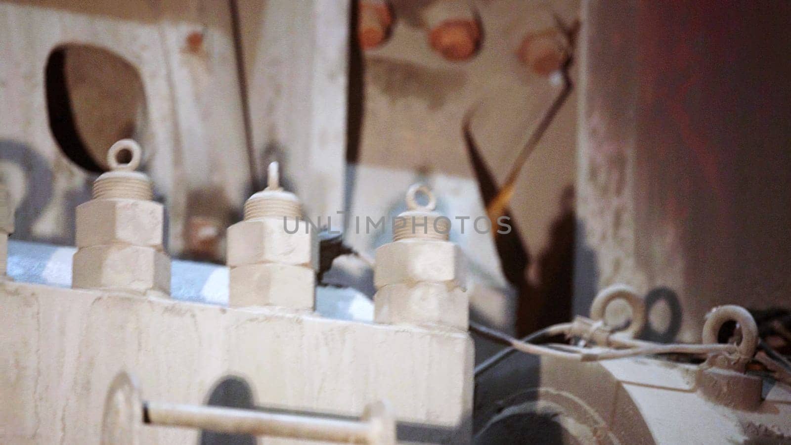 A thorough detailed view of various machinery parts, prominently showcasing bolts and connectors in a dusty setting. Stock Clip