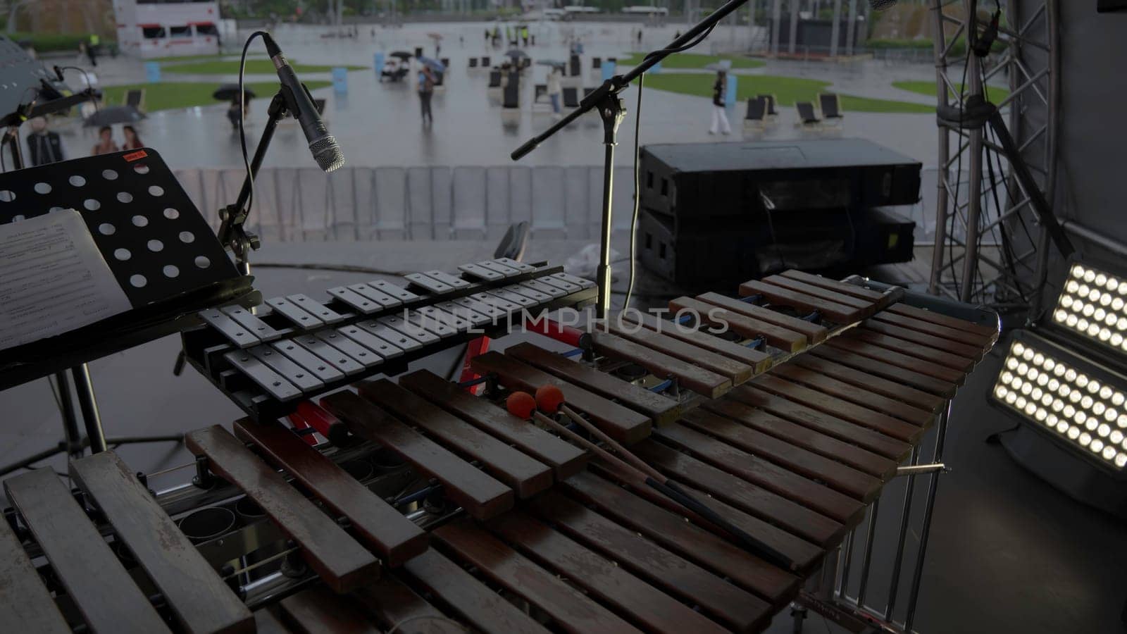 An artistic representation shows a xylophone setup designed for outdoor music performances in light rain. Clip