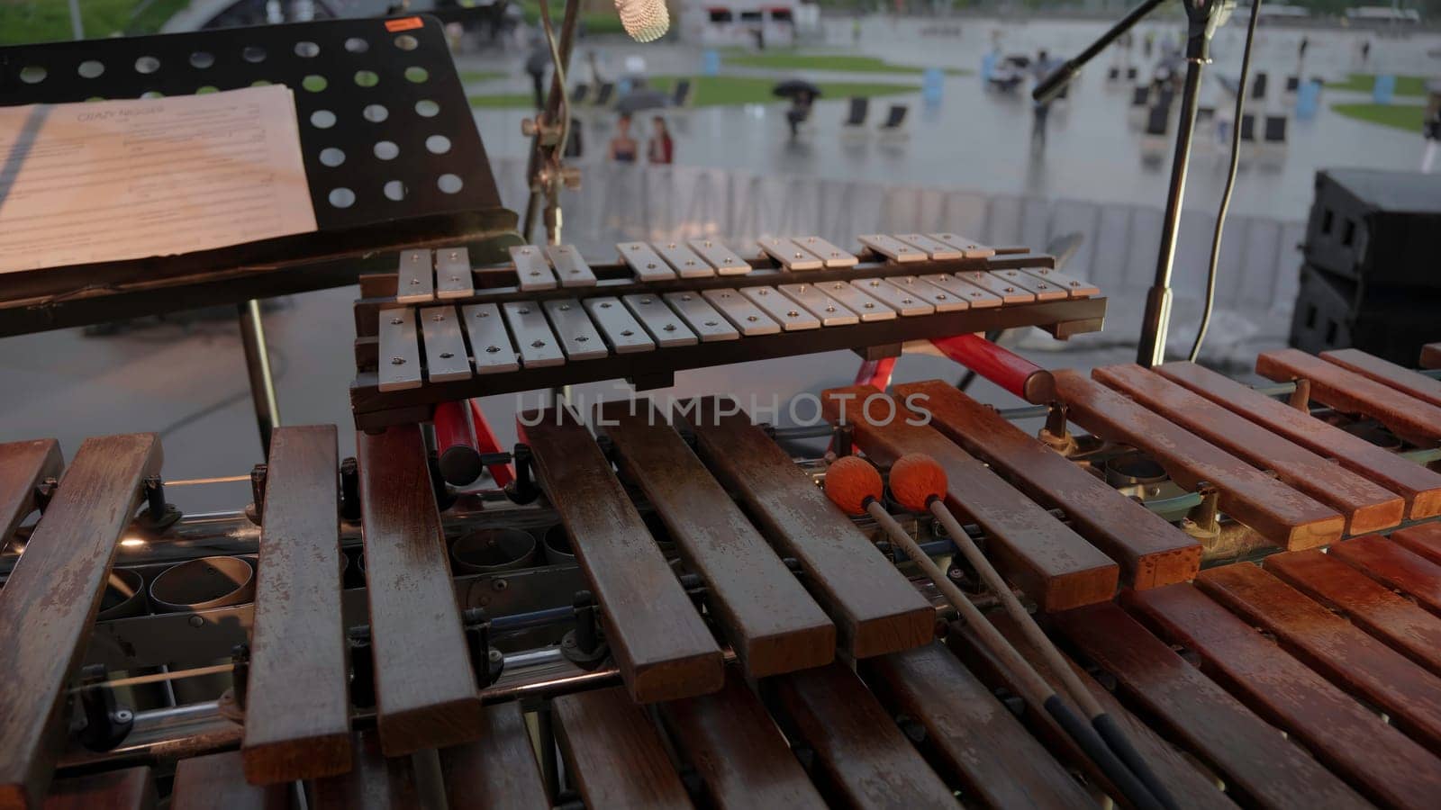 An artistic representation shows a xylophone setup designed for outdoor music performances in light rain. Clip