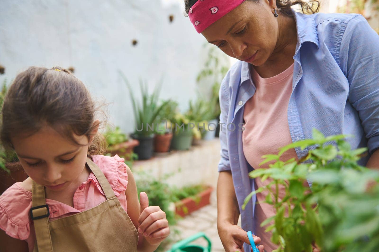 A mother and daughter share a moment of gardening together in a vibrant home garden, nurturing plants and bonding. The scene captures patience, care, and connection with nature.