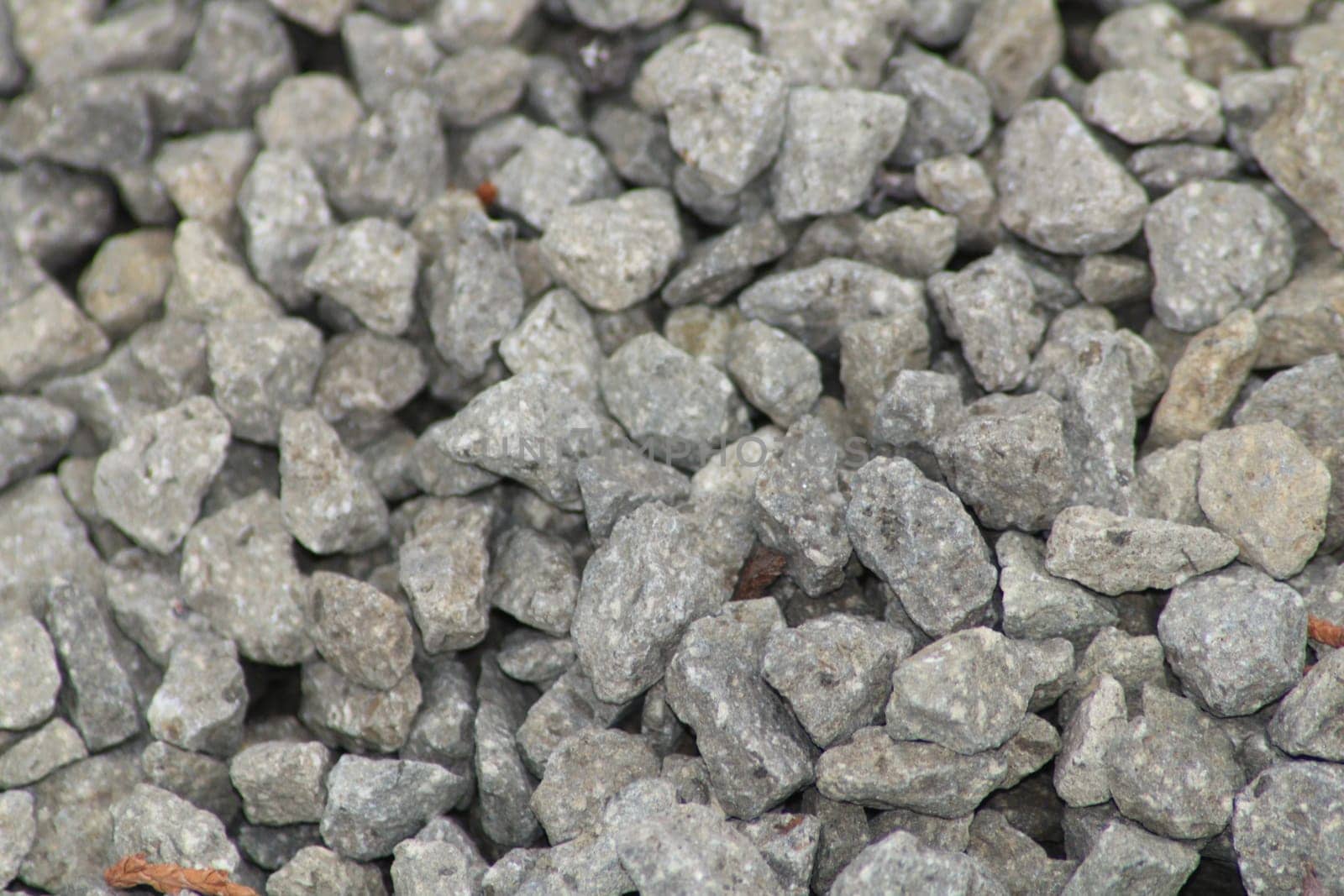 Close-up view of gray crushed stone aggregate, showcasing various sizes and shapes of the stones suitable for construction and landscaping applications.