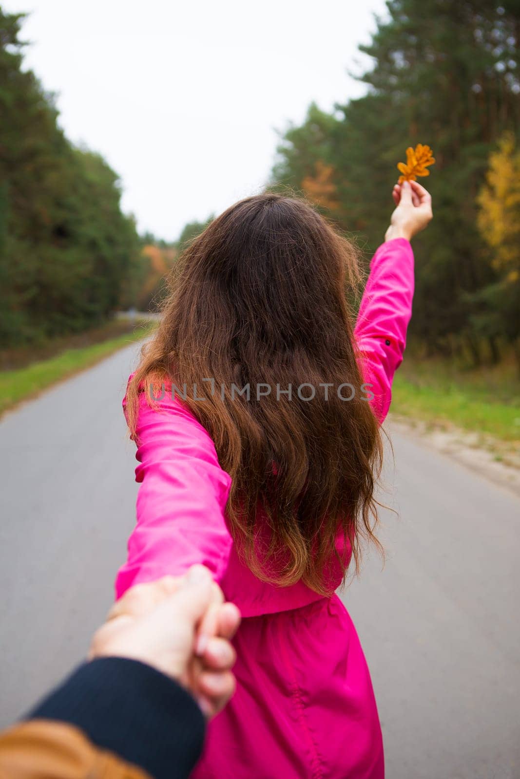 the girl is standing on the road holding a yellow leaf by sfinks