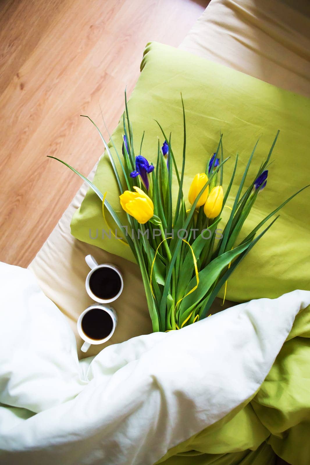 two cups of coffee and a bouquet of beautiful flowers lie in bed-happy morning by sfinks