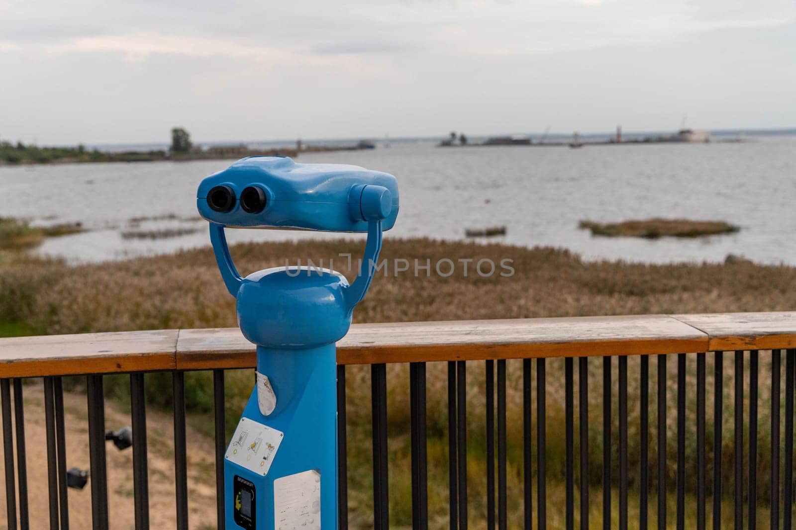 Metal blue stationary outdoor binoculars on the observation deck overlooking the sea. paid binoculars for tourists to view the sights.