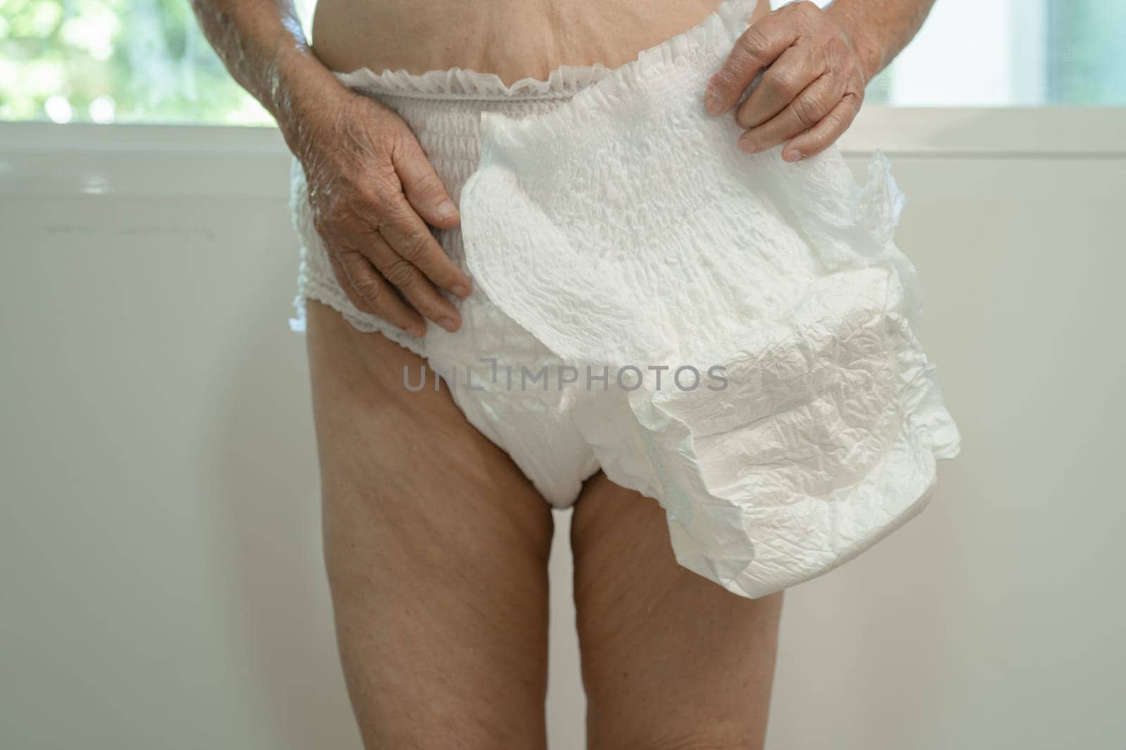 Asian senior woman patient wearing incontinence diaper in hospital, healthy strong medical concept. by pamai