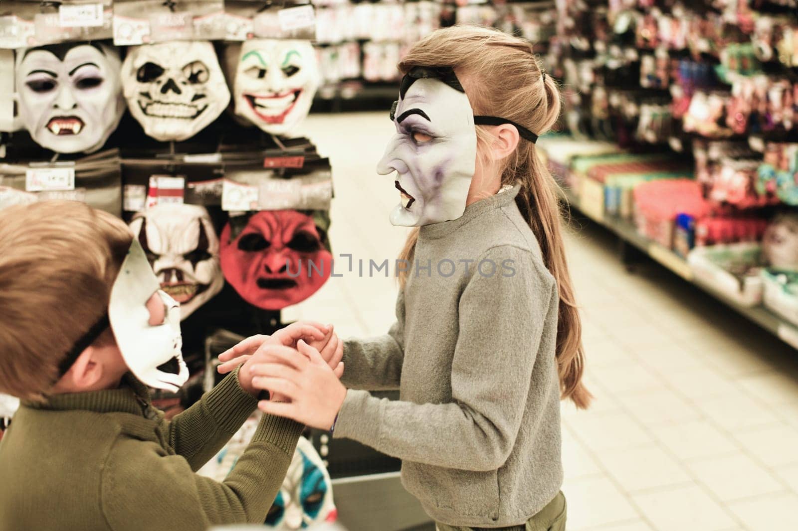 The kids chooses the masks at a store for halloween by Godi