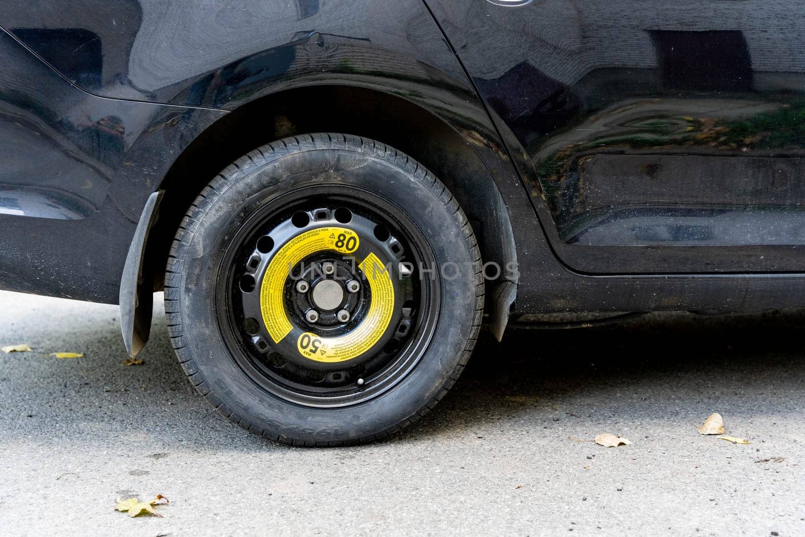 a black passenger car with a spare wheel installed is parked on the road by audiznam2609