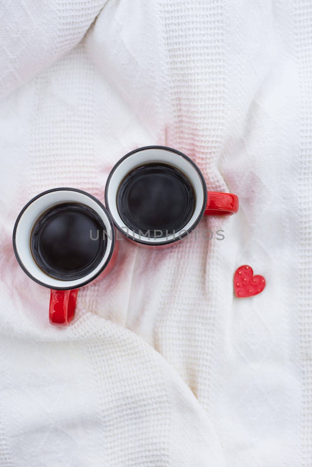 Romantic still life, two red cups of coffee on a white plaid. Valentine's Day concept. by sfinks