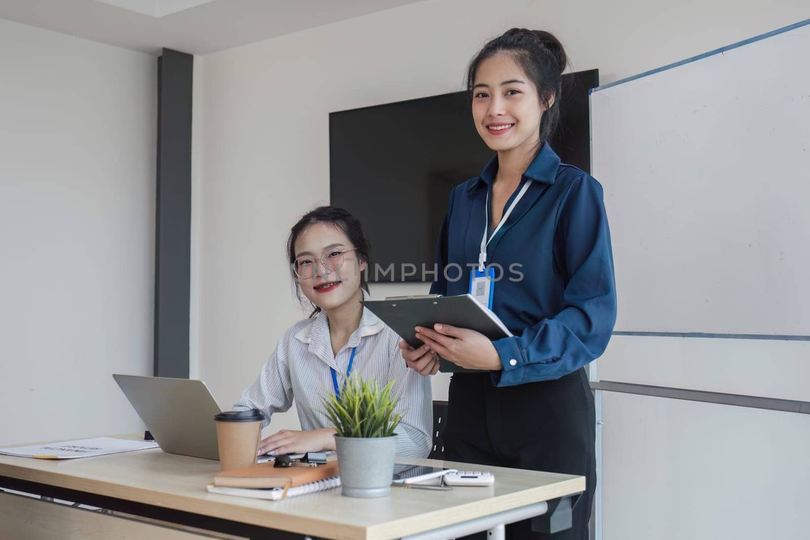 team business people talk project strategy at office meeting room. Businesswoman discuss project planning with colleague at modern workplace while having conversation and advice on financial report by wichayada