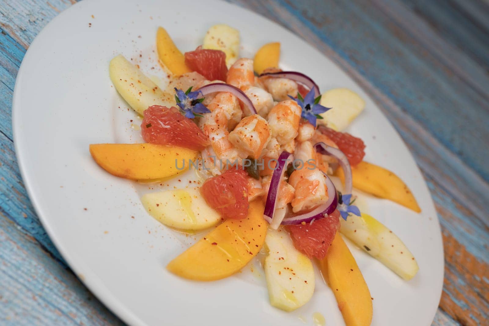 RECIPE CEVICHE OF SHRIMPS AND SCALLOPS WITH CITRUS FRUIT, LEMON, LIME, SQUEEZED ORANGE, GRAPEFRUIT AND FRUIT, PERSIMMON, APPLE, SEASONED WITH ESPELETTE PEPPER. High quality photo