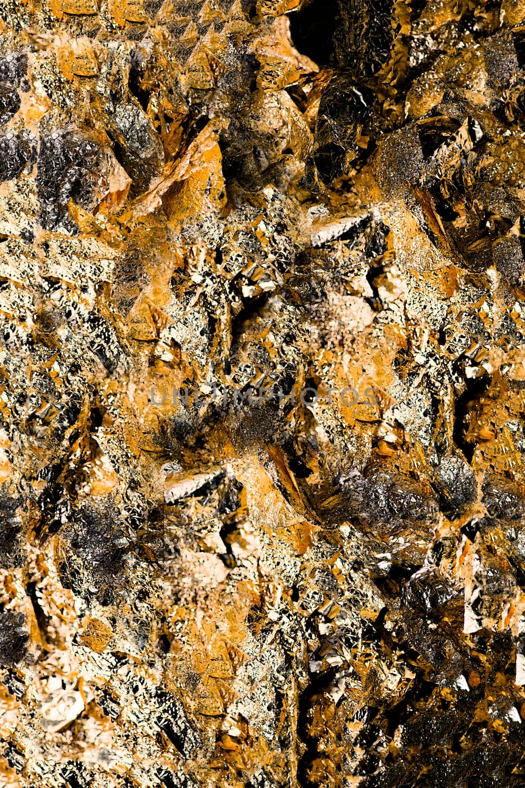 Background of a shiny crumpled foil surface in golden color close-up