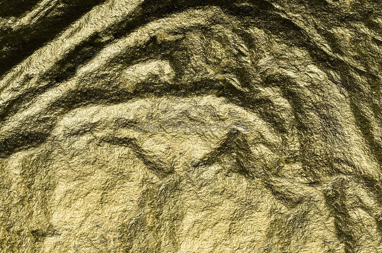 Rough, heavily crumpled golden foil in close-up