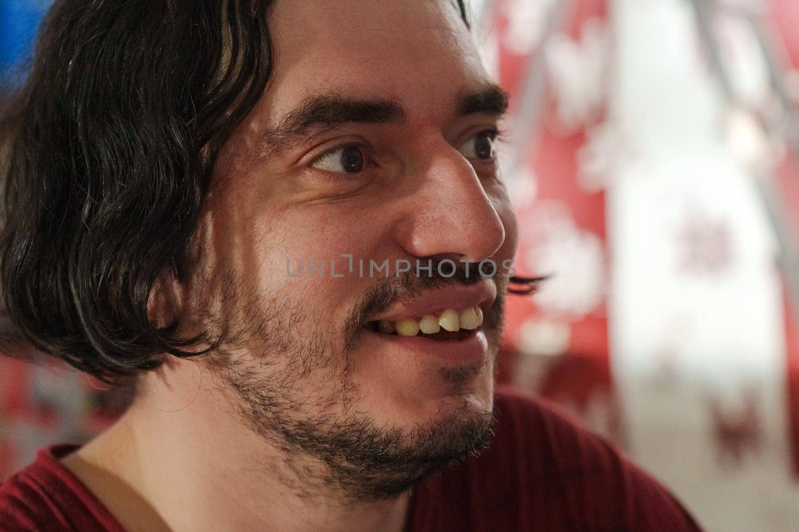 A contemplative moment captured in an artistic environment featuring a man with expressive features and wavy hair at an intimate gathering