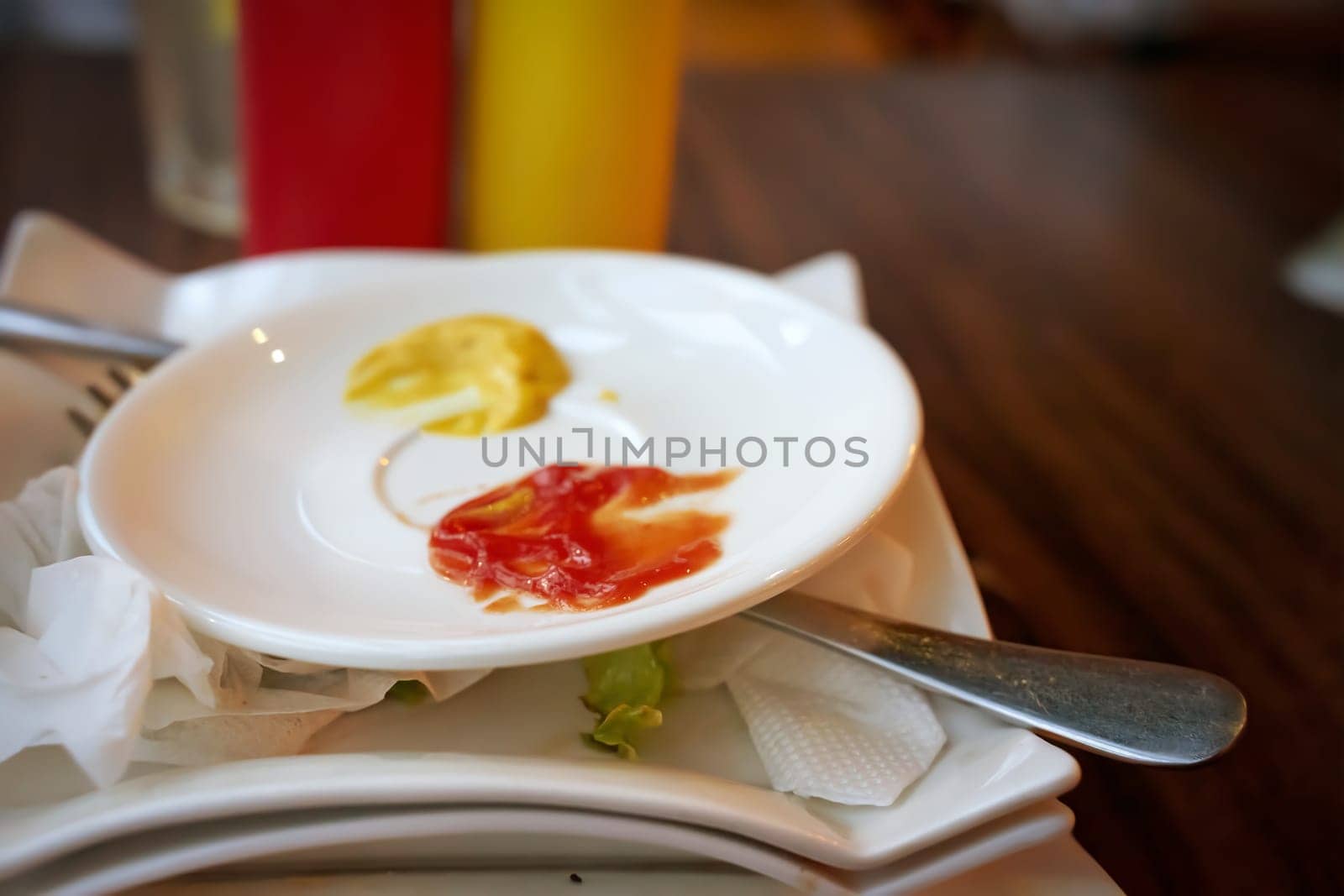Closeup of vibrant ketchup and mustard on a small plate, perfect for diner and foodrelated themes