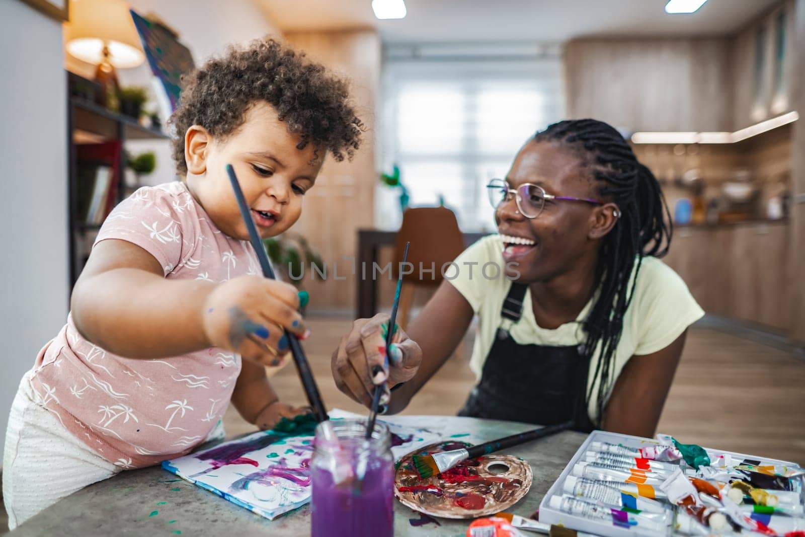A child and a mother share a delightful artistry experience, painting.