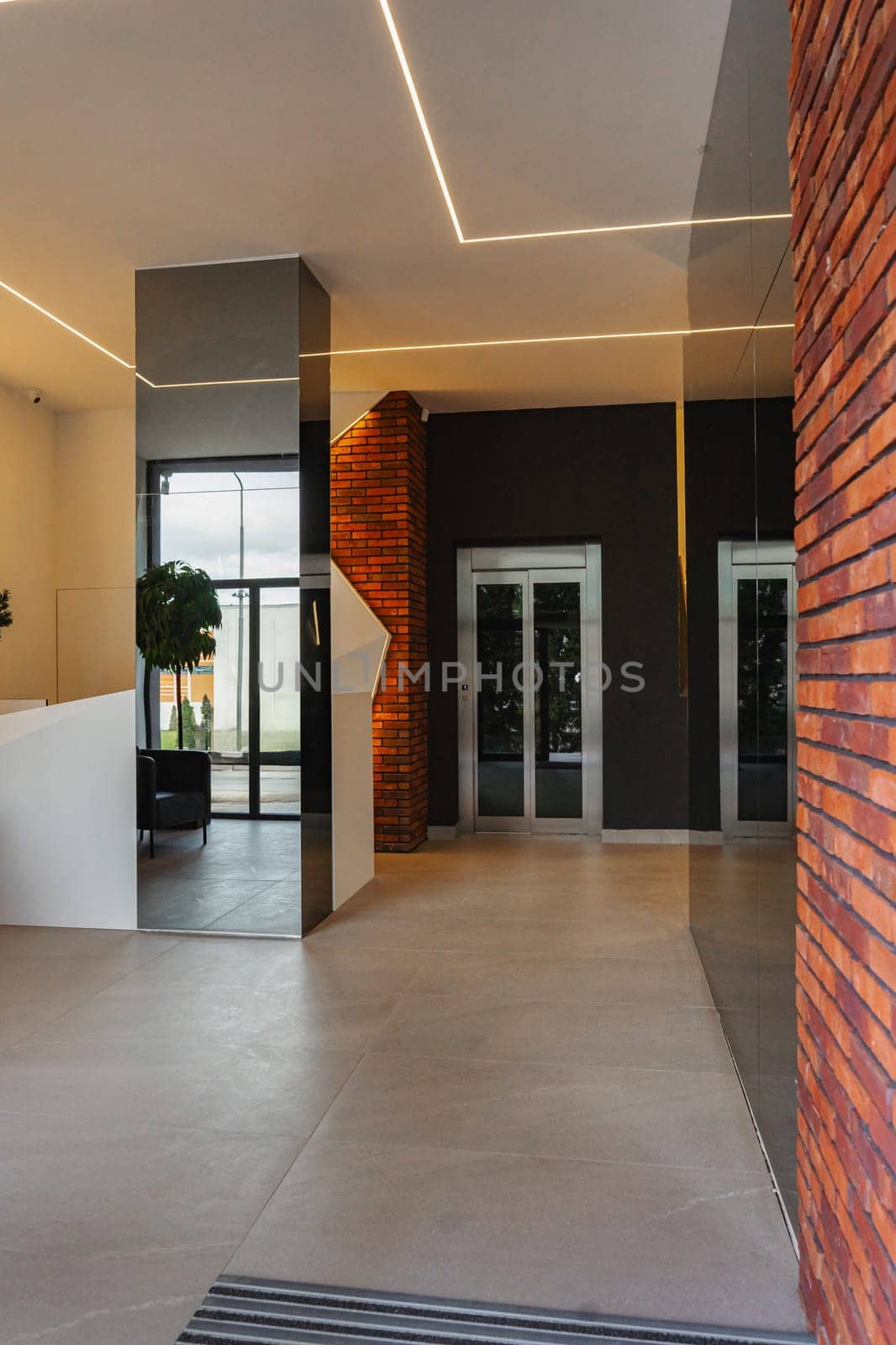 The room features a sturdy brick wall with a simple wooden door. The door appears closed, indicating privacy and security. The brick wall adds texture and character to the space.