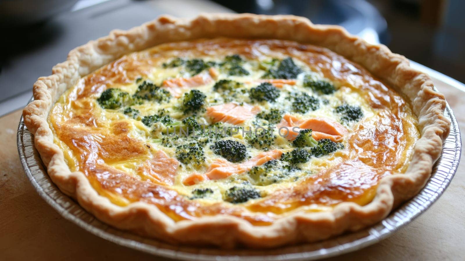 Broccoli and salmon quiche on wooden table, savory pastry and gourmet cuisine concept.