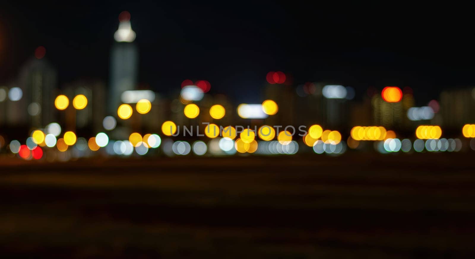 Blurred city lights create a dynamic urban nightscape, featuring skyscrapers and a vibrant mix of colors. warm tones dominate the scene, reflecting an energetic yet serene ambiance. suitable for concepts like urban life and nightlife.