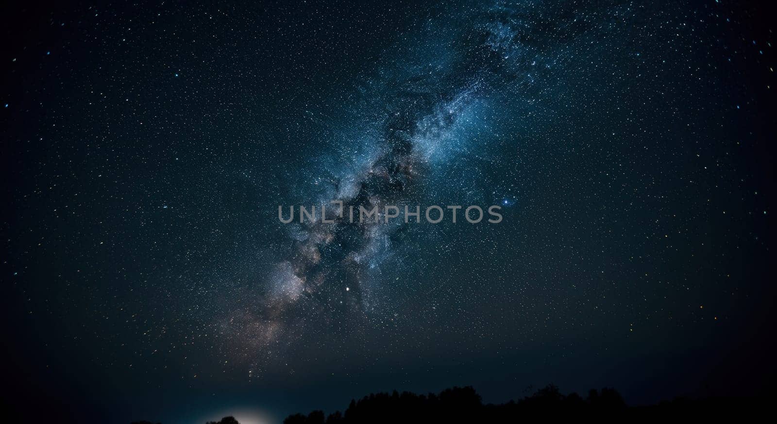 A breathtaking display of the milky way galaxy stretching across a clear night sky. the dense starry expanse casts a luminous glow, while a forested horizon adds depth to this stunning celestial scene.