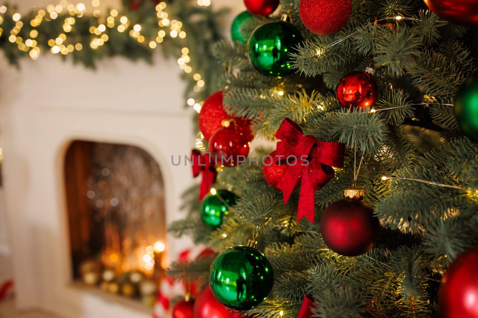 Christmas red bow on a tree, close-up, against the background of a fireplace, stylish New Year's decor