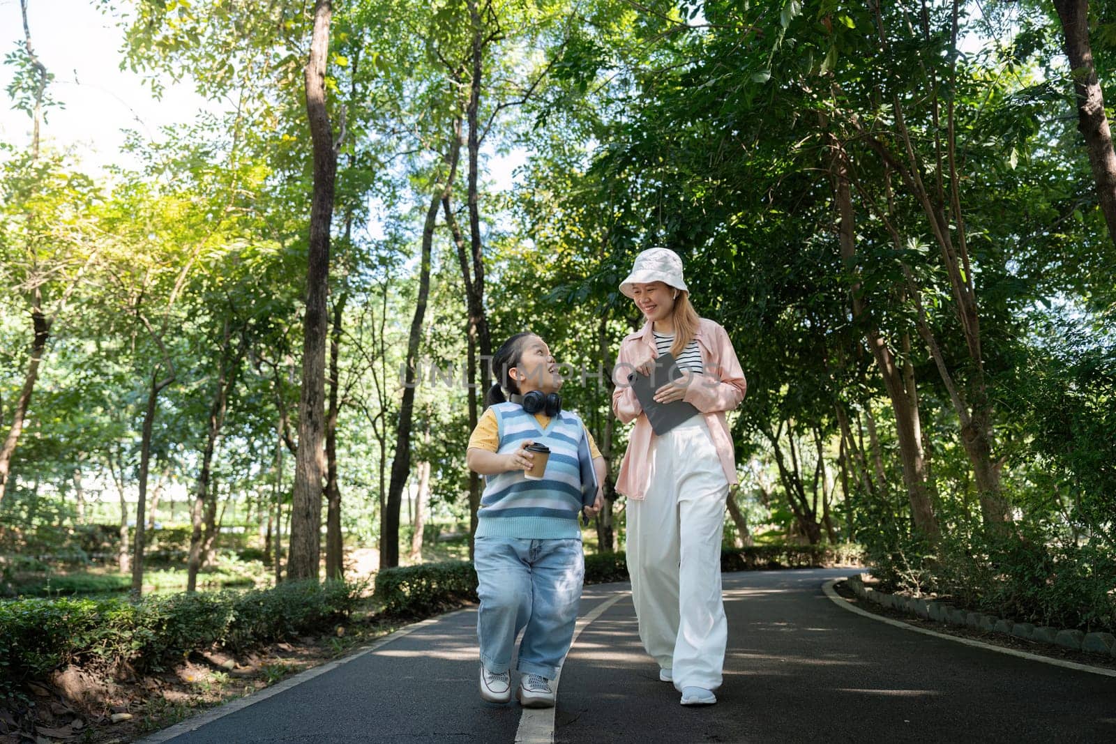Two friends enjoying a walk in the park, highlighting diversity and inclusion with a focus on achondroplasia.