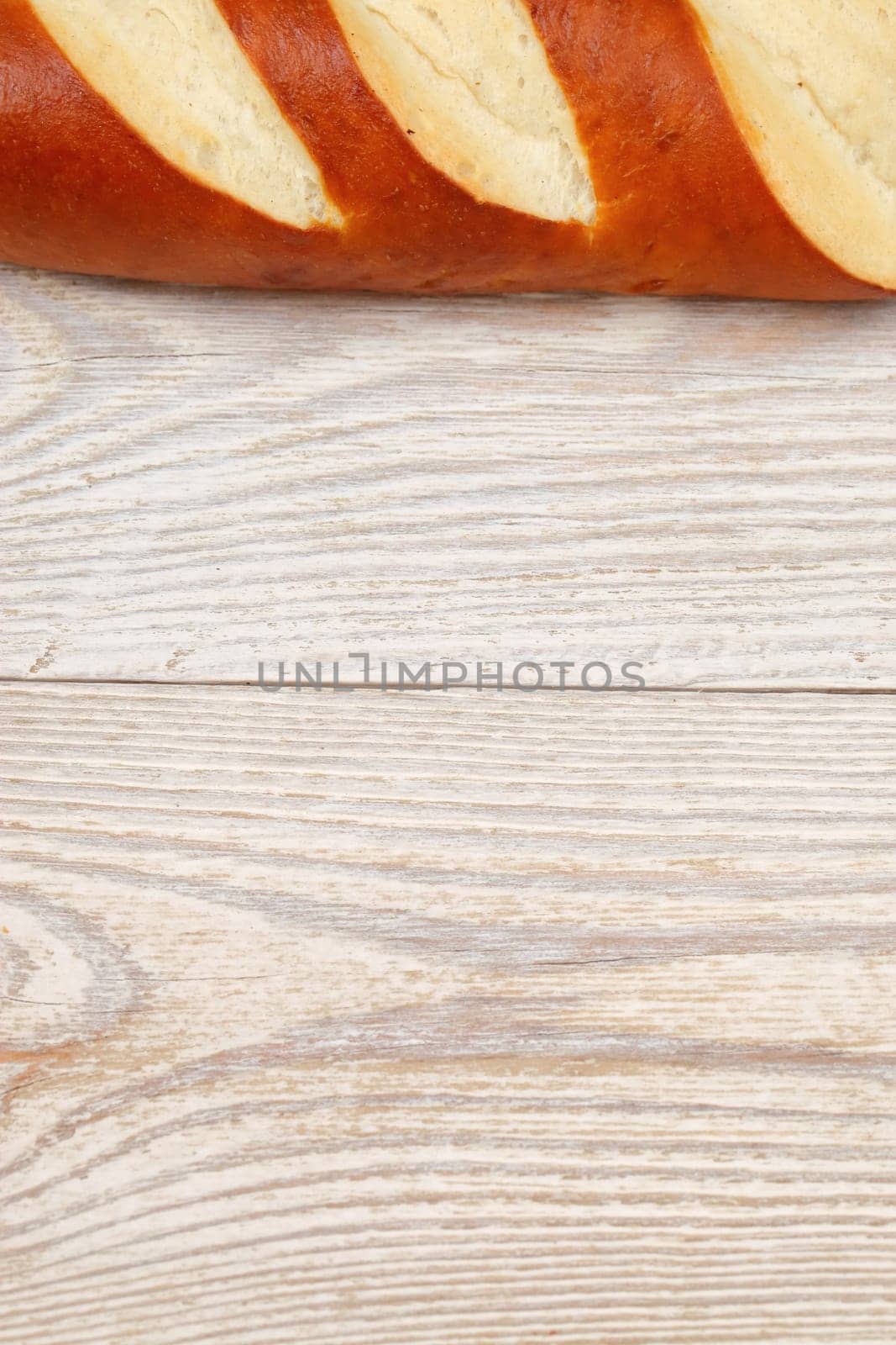 An artisan bread loaf is beautifully artfully displayed on rustic wood, making it perfect for culinary themes