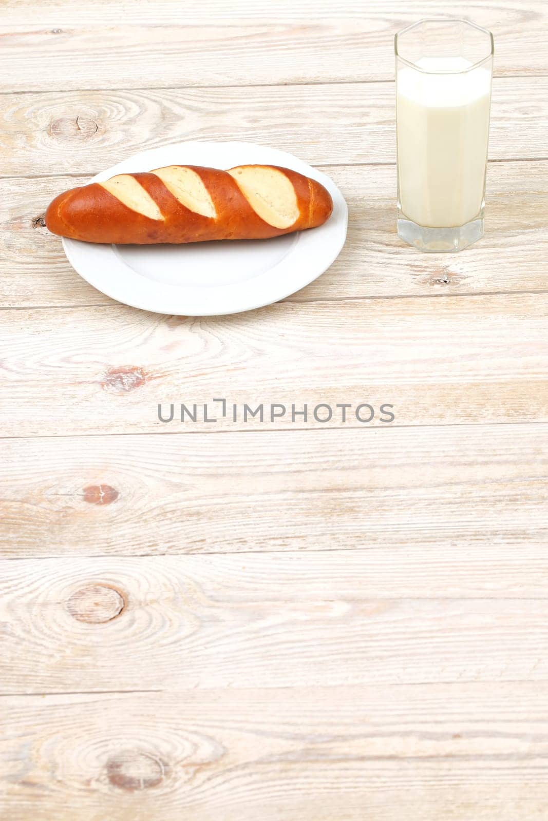 A deliciously fresh baked pastry, perfectly served alongside a cool glass of milk on a rustic wooden table