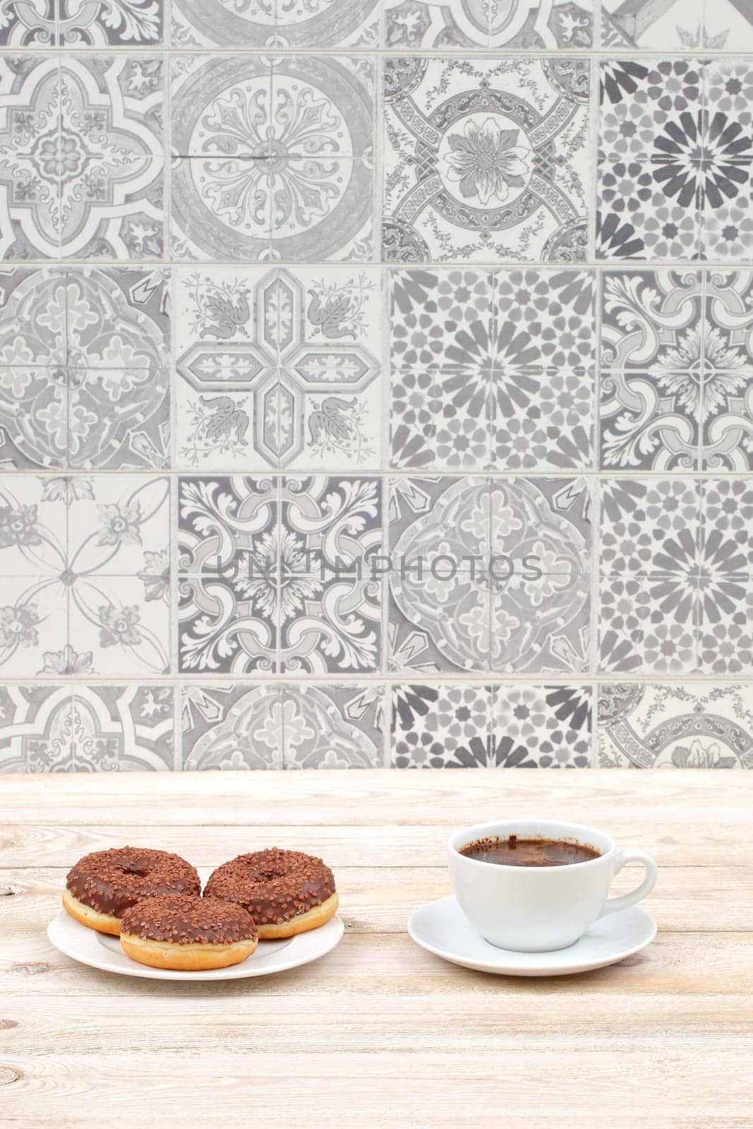 A delightful coffee and delectable donuts setup is beautifully arranged against a stylish patterned backdrop