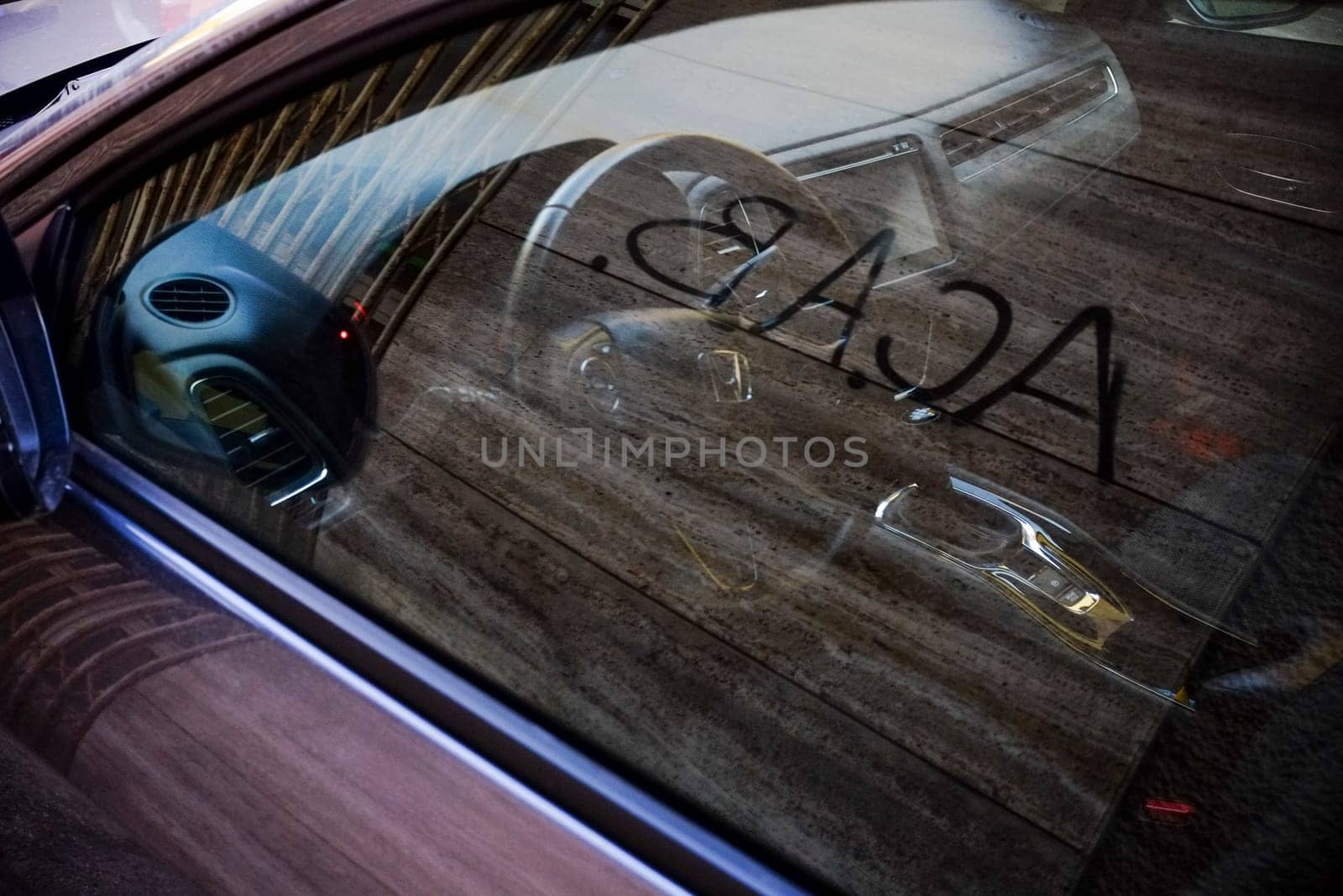 Cremona, Itally - October 6th 2024 Contemporary car interior with wooden fence reflection, featuring steering wheel, gear stick, and dashboard