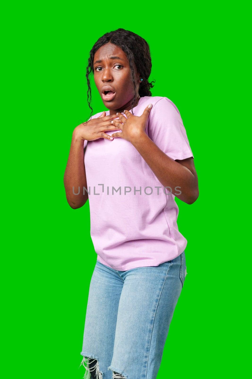 Surprised young woman against a vibrant green background expressing astonishment or shock close up