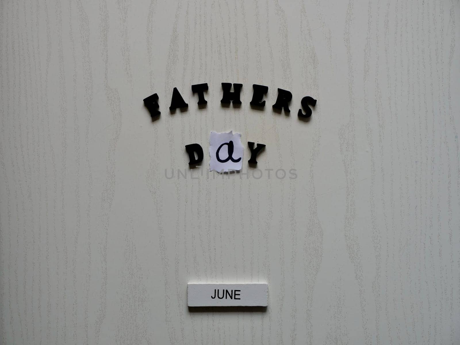 Lettering father in black letters on grey background on father's day close-up