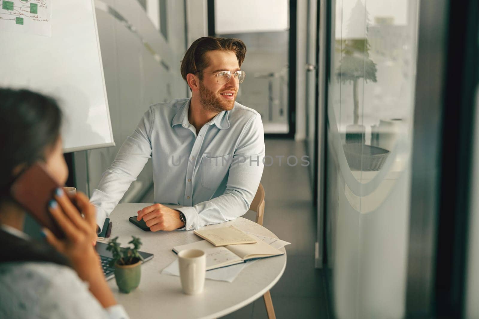bBusinessman sitting in meeting room and looking at side on colleague background. High quality photo