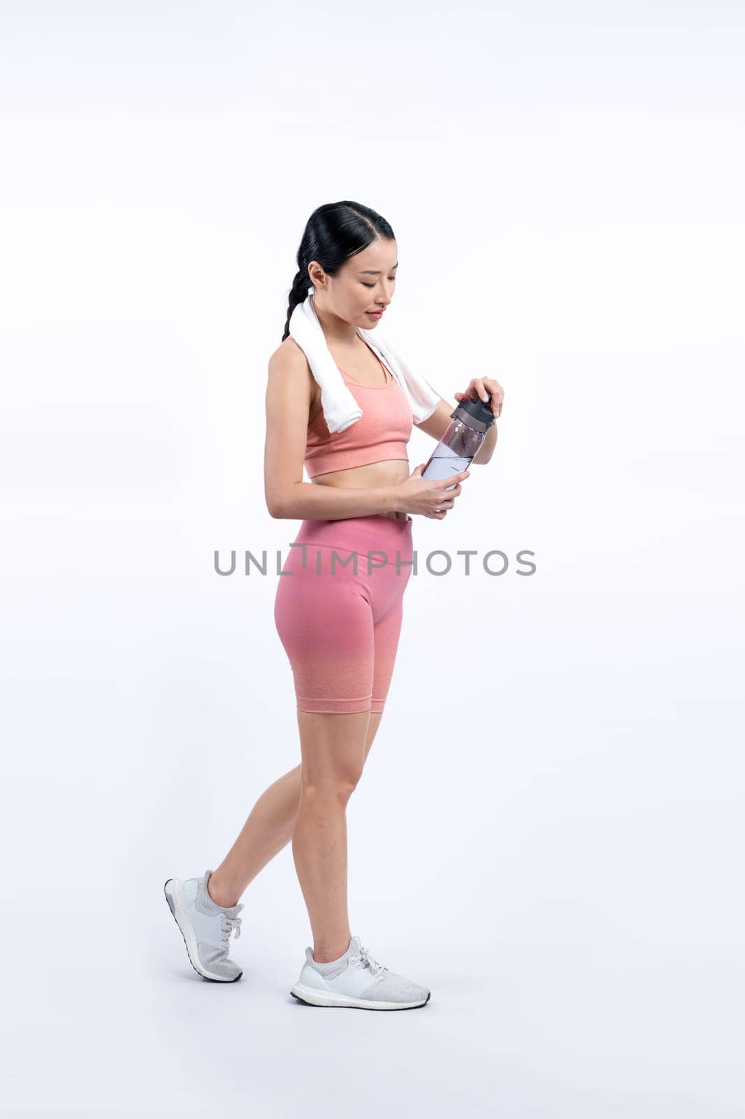 Athletic and sporty asian woman resting and drink water after intensive cardio workout training. Healthy exercising and fit body care lifestyle pursuit in studio shot isolated background. Vigorous