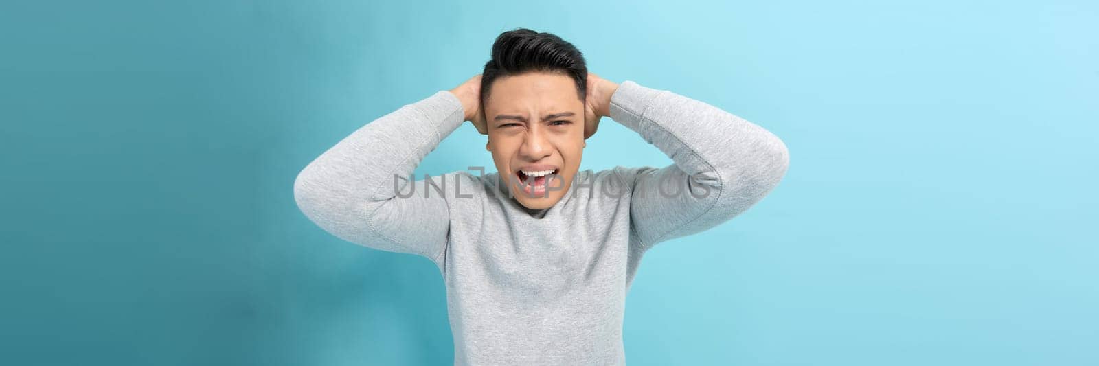 Young Asian businessman shouting, angry expression.