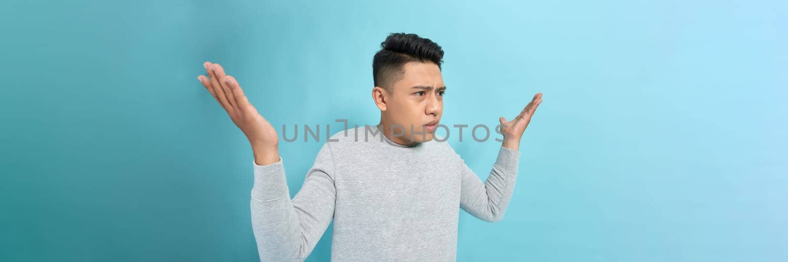 handsome young guy irritated scolding argument hands isolated on blue color background