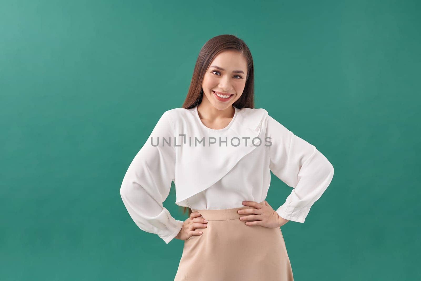 Smiling, beautiful asian woman posing on a green wall. by makidotvn