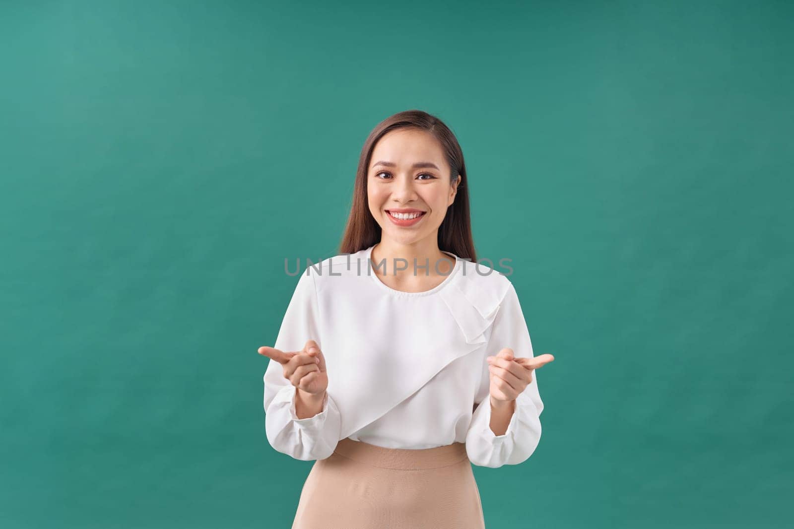 Beautiful young woman in dress pointing fingers sideways, show two ways, giving choice and smiling by makidotvn