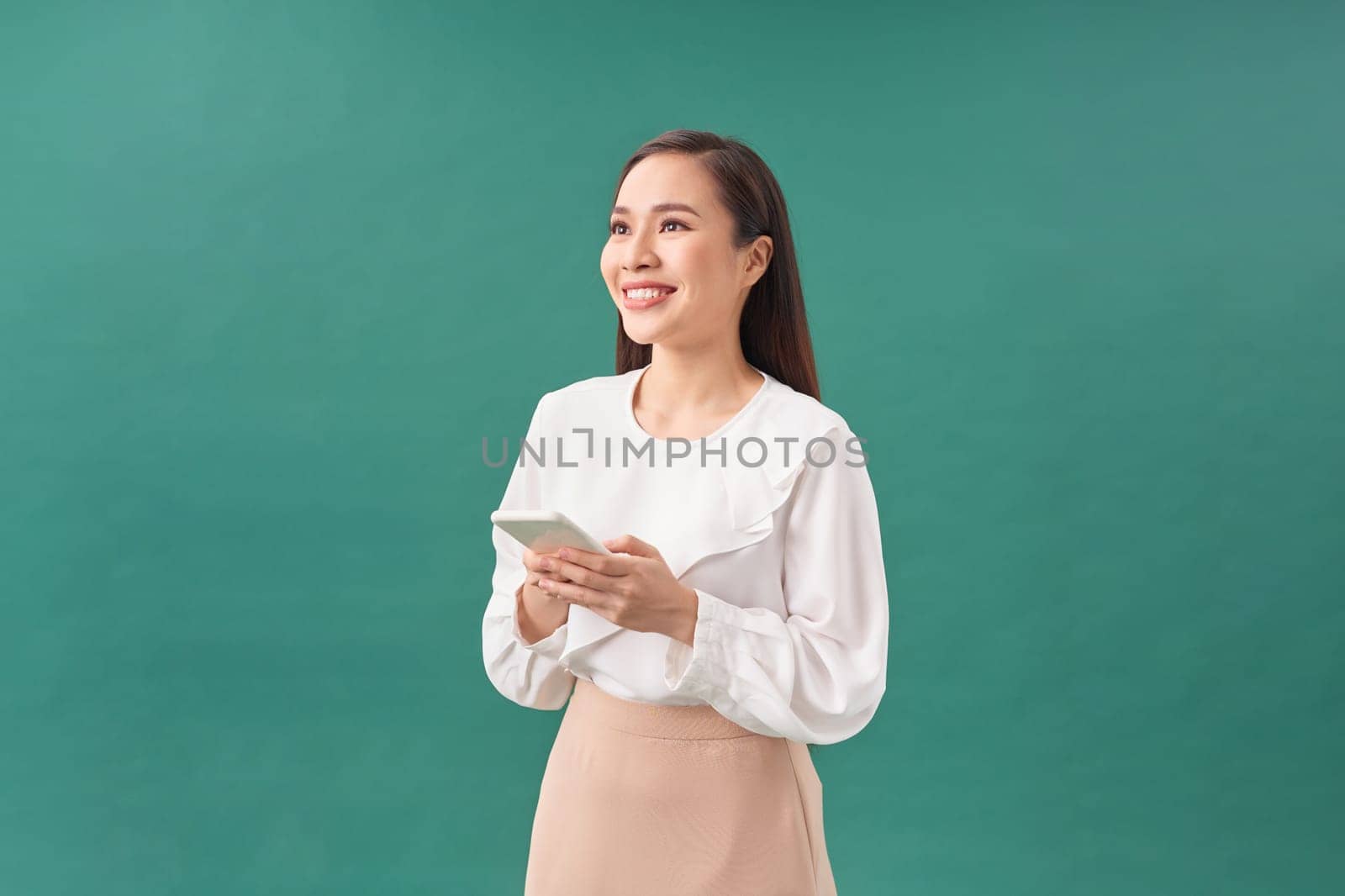 Young asian girl using smartphone typing message smiling with a happy and cool smile on face