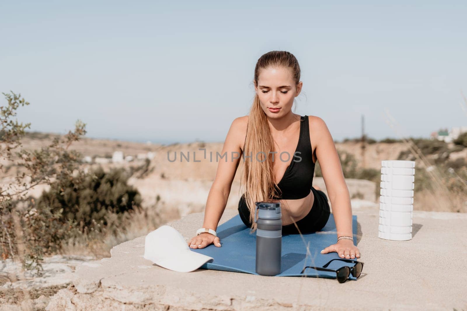 Fitness woman sea. Outdoor workout on yoga mat roller in park near to ocean beach. Female fitness pilates yoga routine concept. Healthy lifestyle. Happy fit woman exercising with rubber band in park. by panophotograph