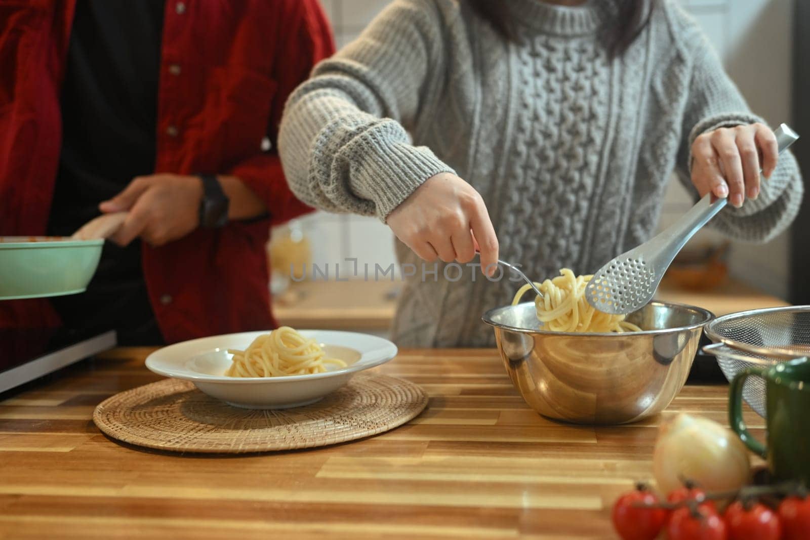 Young woman preparing homemade pasta dish in kitchen during the holiday season.