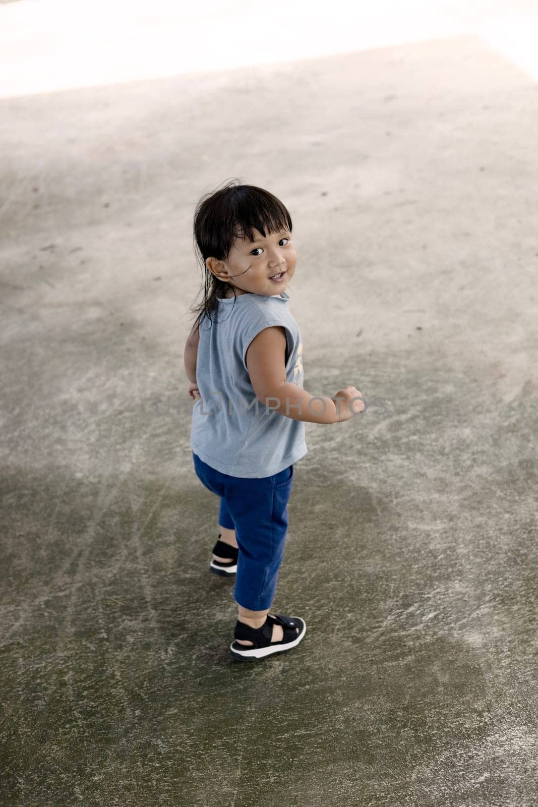 Little boy walking alone on the playground.