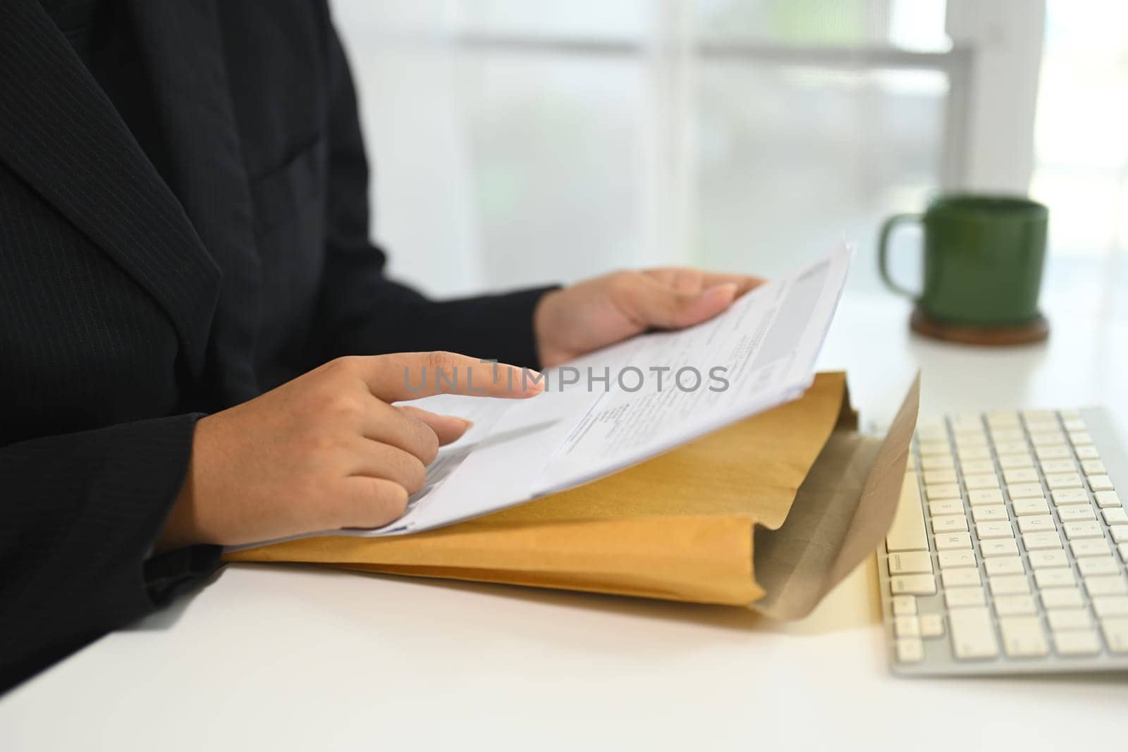 Close up of businesswoman analyzing important documents at desk.