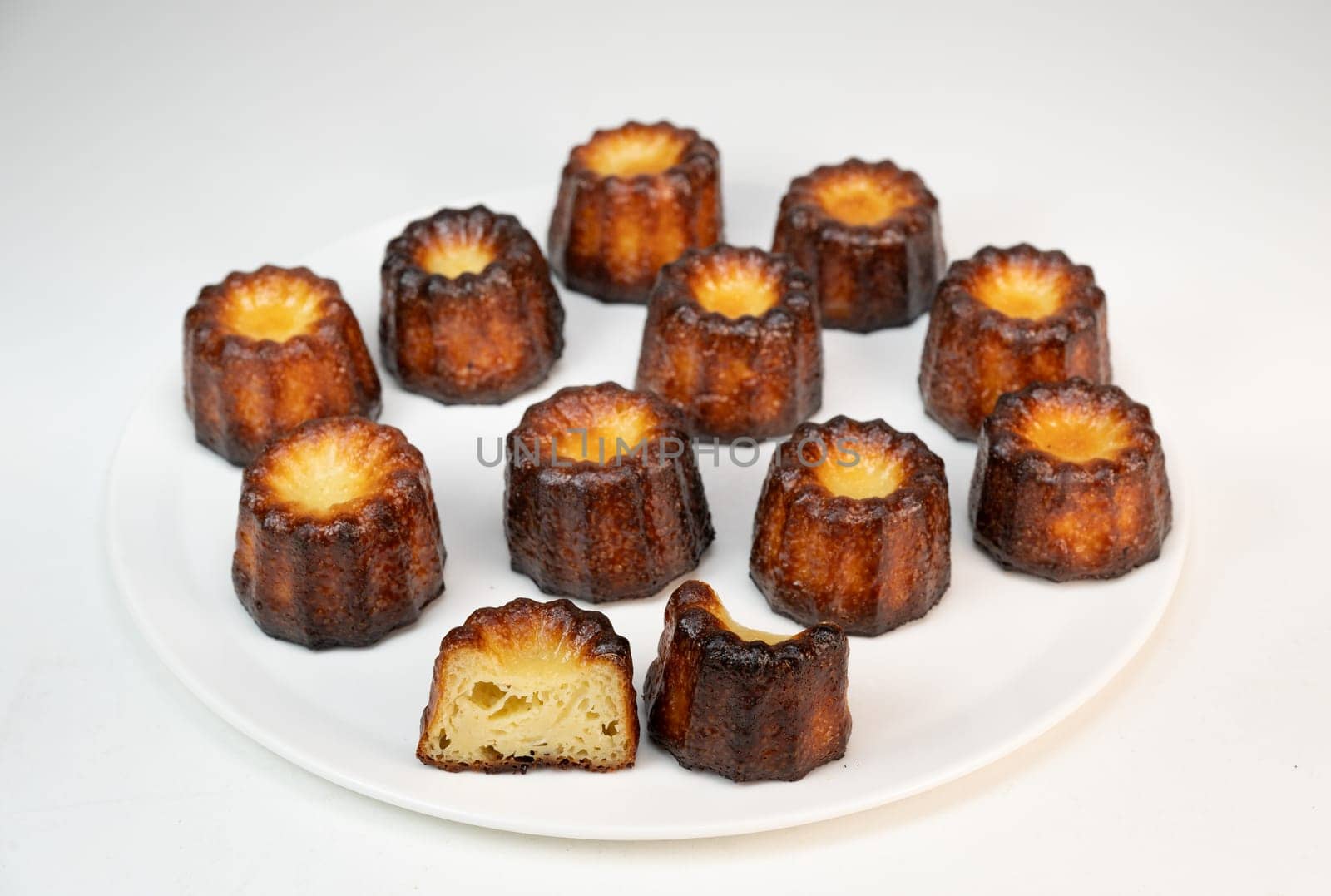Caneles de bordeaux, traditional French sweet dessert with white table background, High quality photo