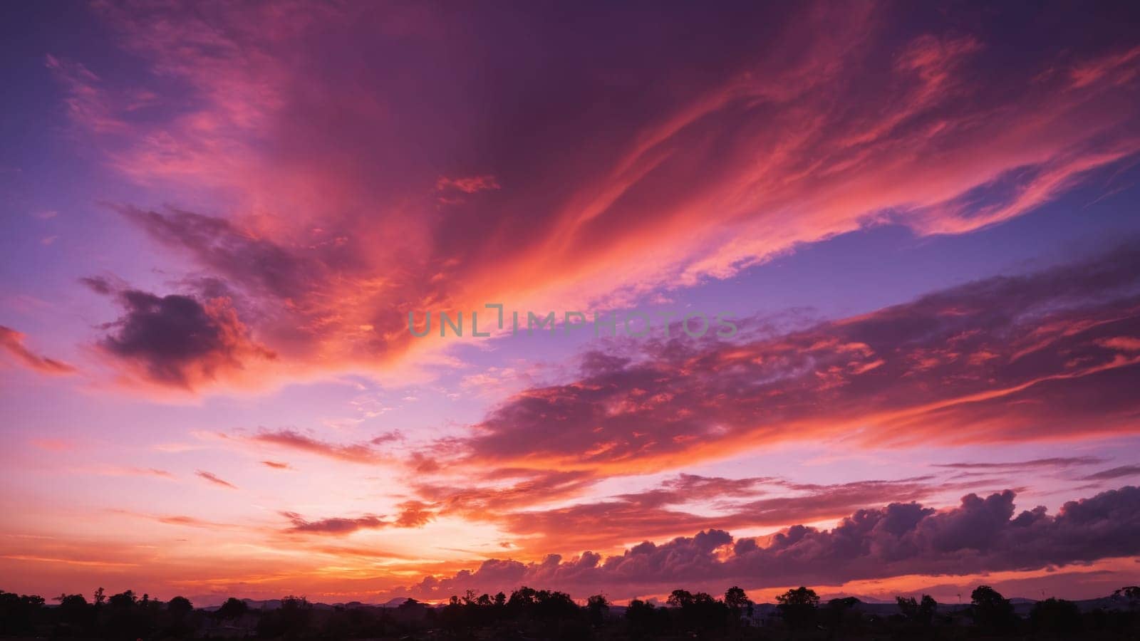 As the day transitions into night, the sky bursts with vivid hues of orange, pink, and purple, creating a breathtaking backdrop to the soft clouds drifting by at dusk.