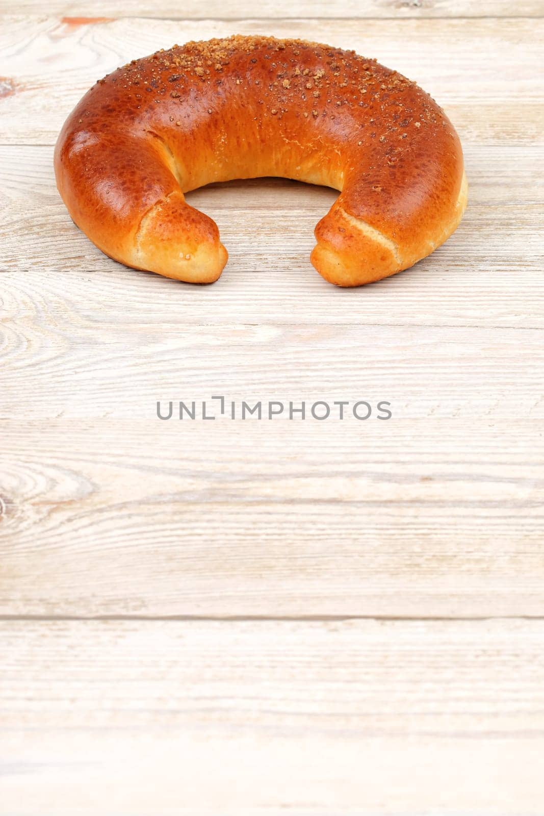Freshly baked crescentshaped bread is beautifully displayed on a rustic wooden table, inviting all to enjoy it