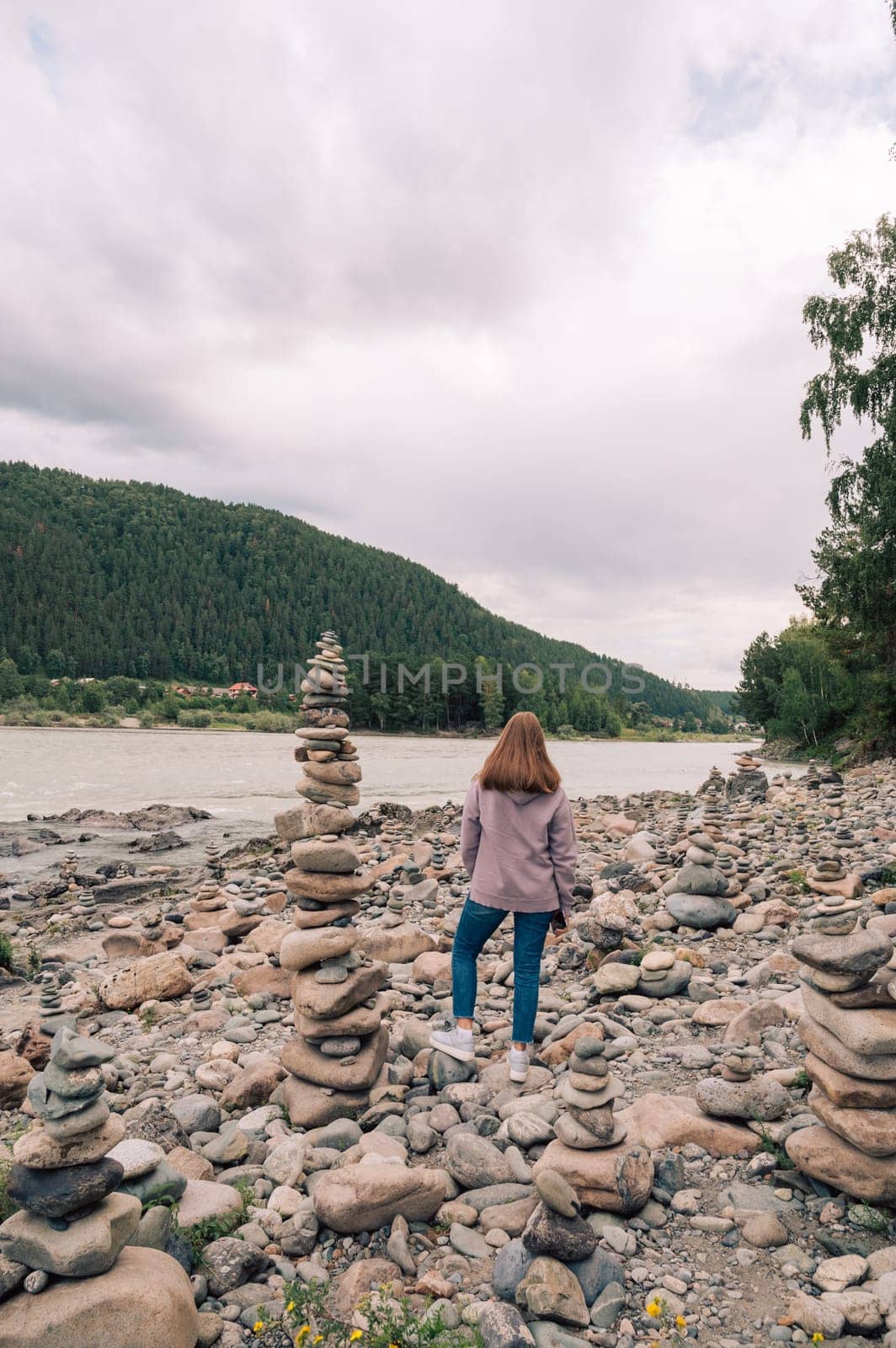 Woman at the river Katun at summer day. Trip on Altai Mountains in Altai Republic